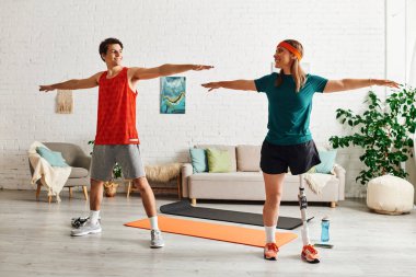 Spor elbiseli bir çift, evlerindeki spor salonunda yoga minderinin üzerinde esniyorlar..