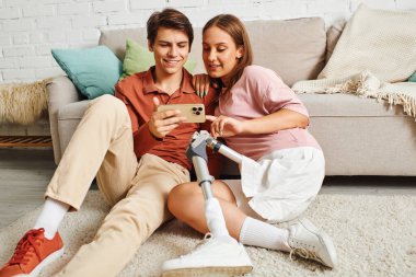 Genç bir çift telefona bakarken birbirlerine eşlik etmekten zevk alır..