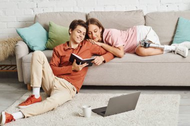 Birkaçı evde dinlenir, biri kitap okurken diğeri kanepede dinlenir..