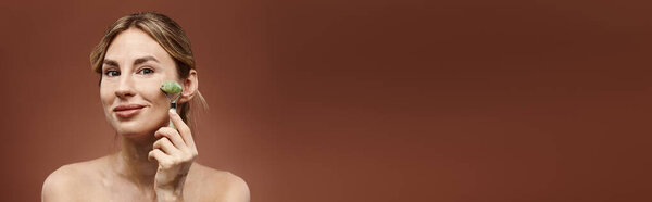 Молодая женщина с витилиго использует нефритовый ролик на лице, демонстрируя простой, но эффективный режим красоты.