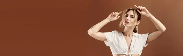 stock image A young woman with vitiligo poses confidently in a white summer outfit against a beige background.