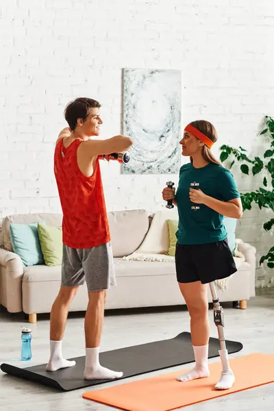 stock image A woman with a prosthetic leg works out with her boyfriend in their living room.