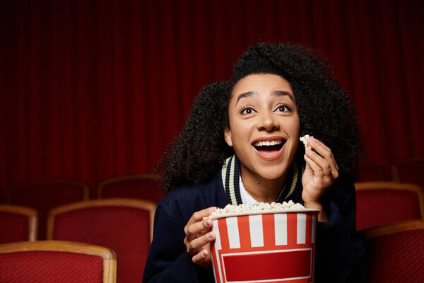 Молодая женщина наслаждается фильмом, очарованным действием на экране.