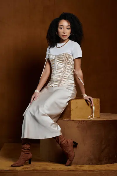 stock image A stylish African American woman in a trendy outfit poses confidently in a studio setting.