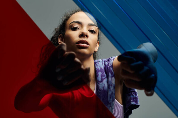 Молодая женщина уверенно позирует в студии с цветным стеклом