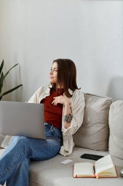 Günlük giysiler içindeki genç bir kadın kucağında dizüstü bilgisayarla koltukta oturuyor. Bir sonraki sosyal medya kampanyası hakkında ne düşündüğünü bilmiyor..