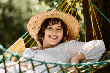 A young woman in a white dress and straw hat relaxes in a hammock, surrounded by lush greenery. clipart