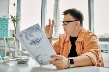 A man with Down Syndrome ponders the menu at a cafe, showcasing the value of diversity and inclusion in daily life clipart