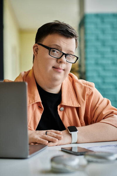 A man with Down syndrome works on his laptop in a cafe, demonstrating the power of inclusion in the freelance world.