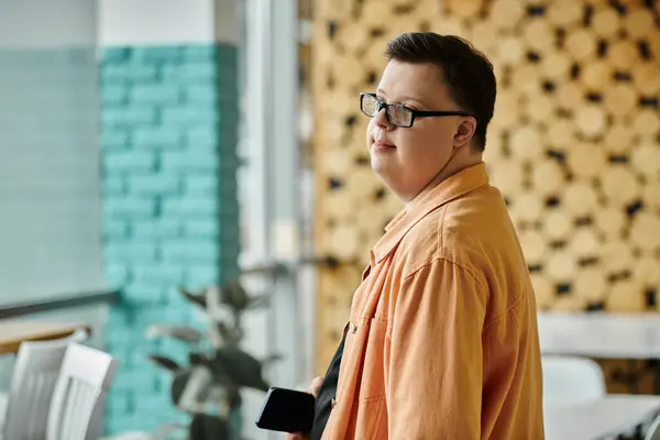 stock image A man with Down syndrome looks off to the side, smiling, in a cafe.