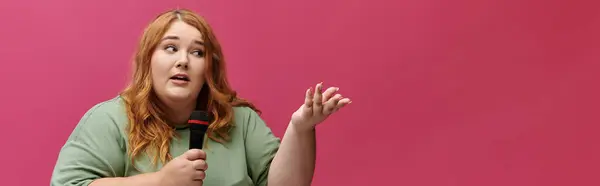 stock image Woman with red hair holding microphone speaks with conviction and gestures right