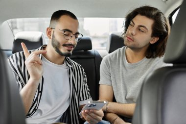 Two men sit in the backseat of a car, engaged in a conversation. clipart