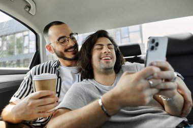 A gay couple laughs and enjoys each other's company in the backseat of a car. clipart