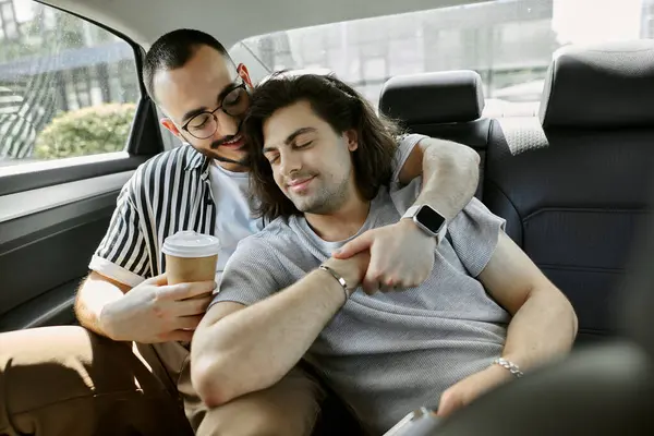 stock image Couple in car, one holding coffee, other resting head on shoulder