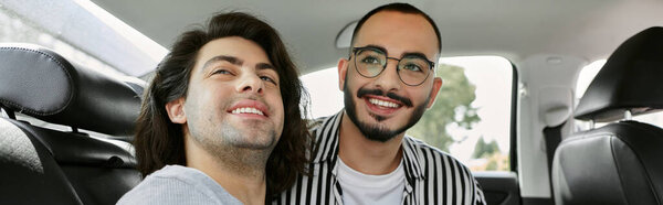 Любящая гей-пара улыбается друг другу на заднем сиденье автомобиля.