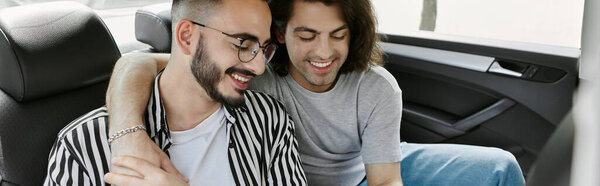 A gay couple shares a tender moment in the backseat of a car.