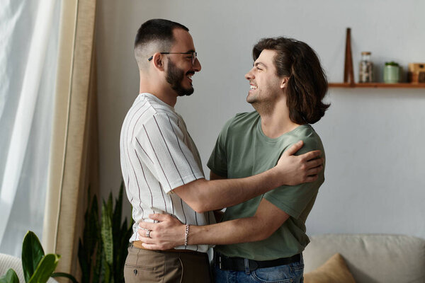 A gay couple embraces lovingly in their home, bathed in the warm light from a nearby window.