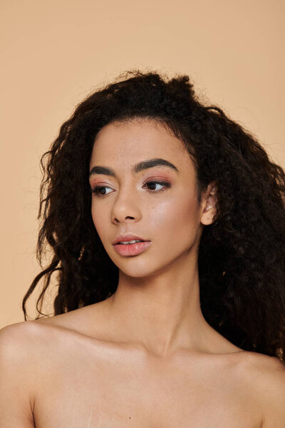 A young woman with curly hair and natural makeup gazes off to the side, her expression serene.