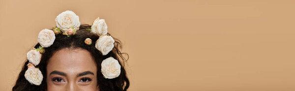 Молодая афроамериканка с обнаженными плечами улыбается, украшенная белыми цветами в волосах.