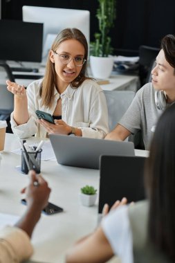 Genç profesyoneller modern bir ofiste yeni başlayan bir projede işbirliği yapıyorlar