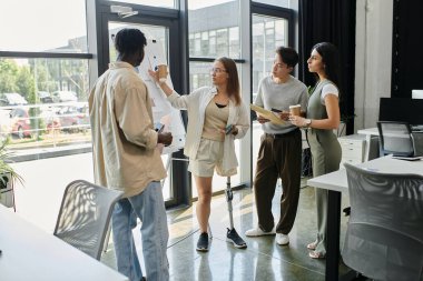 Çağdaş ofis ortamında dört meslektaş bir projeyi tartışıyor.