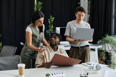 Profesyonel bir ortamda üç meslektaşı yeni bir proje üzerinde işbirliği yapıyor