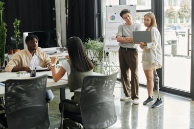 Çağdaş bir ofis ortamında dört meslektaş bir başlangıç projesinde işbirliği yapıyor.