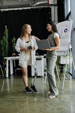 İki kadın modern bir ofiste bir projeyi tartışıyor..