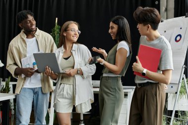 Ofiste fikir alışverişinde bulunan ve iş birliği yapan dört iş arkadaşı..