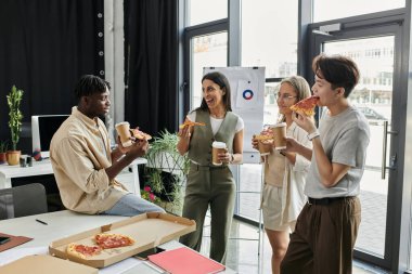 Çağdaş bir ofis ortamında dört meslektaş pizza ve kahve molası veriyor..