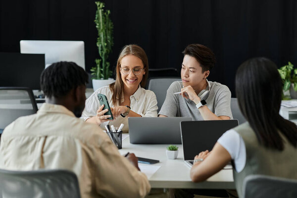 Разнообразная команда молодых профессионалов работает над проектом, ориентированным на смартфон.