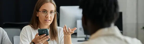 stock image A woman pitches her startup idea while holding her phone.