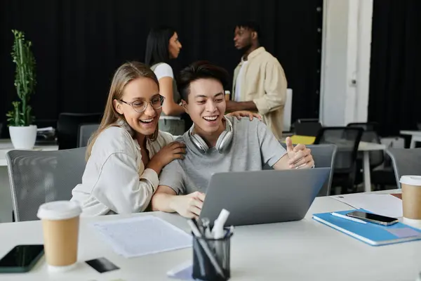 stock image Two young professionals celebrate a breakthrough while working on their startup in a modern office.