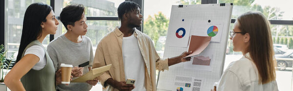 Разнообразная команда из четырех человек обсуждает данные во время презентации.