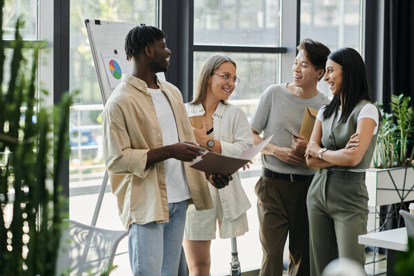 A diverse group of four individuals discuss ideas in a modern office setting.