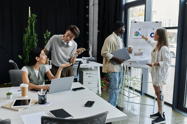 Четверо коллег работают над стартап-проектом в просторном современном офисе.