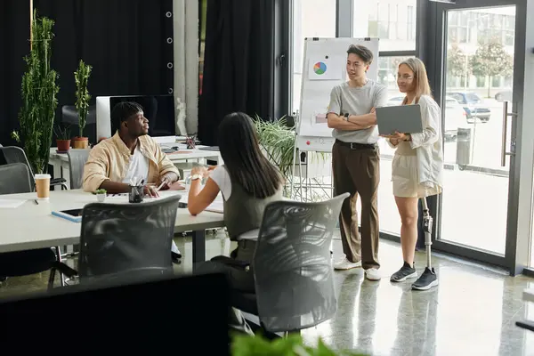 stock image Diverse colleagues collaborate in office, one presents a chart