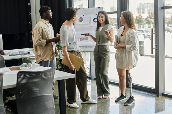 Разнообразная группа людей просматривает данные и обсуждает планы в современном офисном пространстве.