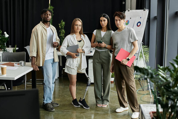 Four young professionals stand in a modern office, looking confident and ready to work.