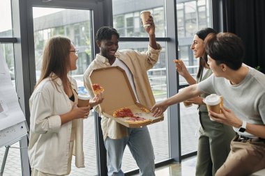 İş arkadaşları yoğun iş günlerinde pizza ve kahvenin tadını çıkarırlar..