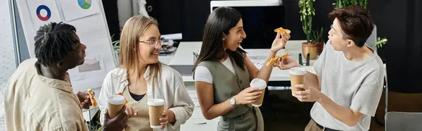 stock image Four coworkers enjoy a break together, sharing coffee and snacks.