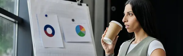 stock image A woman takes a moment to reflect while reviewing charts during a startup strategy session.