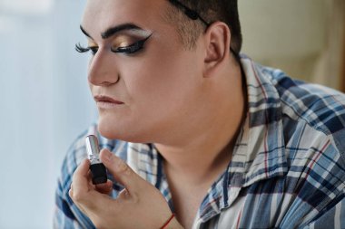 Eşcinsel bir insan detaylara odaklanarak ruj sürer..