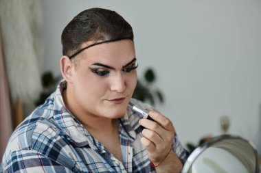 Eşcinsel bir insan şık bir ekose gömleğe makyaj yapar ve özgün benlik duygusunu gösterir..