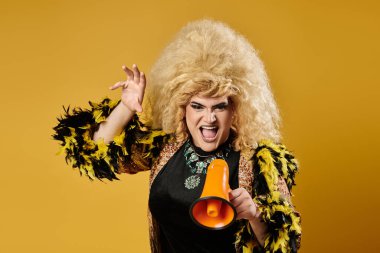 Parlak sarı ve siyah tüylü ceketli tuhaf bir insan bir megafon tutuyor ve kameraya doğru bağırıyor..