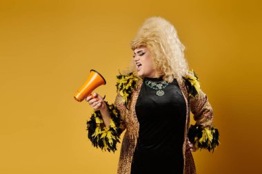 Büyüleyici kıyafetli bir travesti megafona bağırıyor..