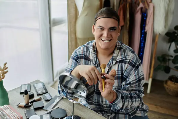 stock image queer person smiles as they apply makeup with tools, ready to express themselves