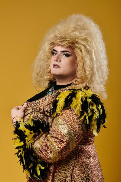 Blonde queer person in bold makeup poses in leopard robe with feathers
