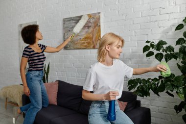 Çok kültürlü lezbiyen bir çift modern dairelerini temizliyor, ev işlerine sevgi dolu ve işbirlikçi bir yaklaşım sergiliyorlar..