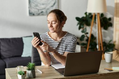 Vitiligo 'su olan neşeli bir kadın rahat bir çalışma alanında telefonuyla iletişim kuruyor..